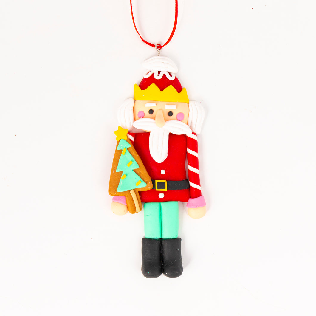 Gingerbread Nutcracker Tree Ornament holding a tree